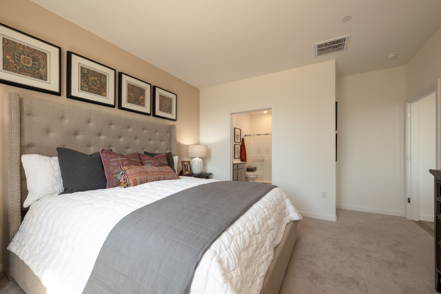 A bedroom with a bed and a lamp.