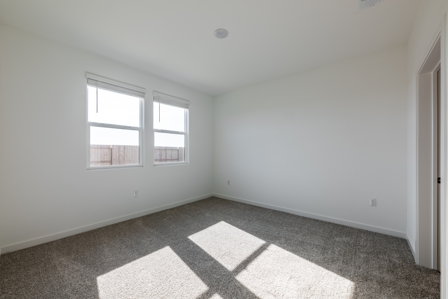 A room with a window and a rug.
