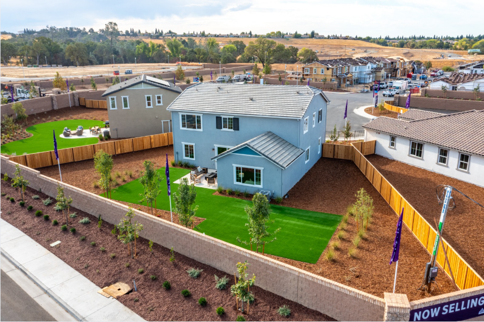 A group of houses with trees and grass around them.