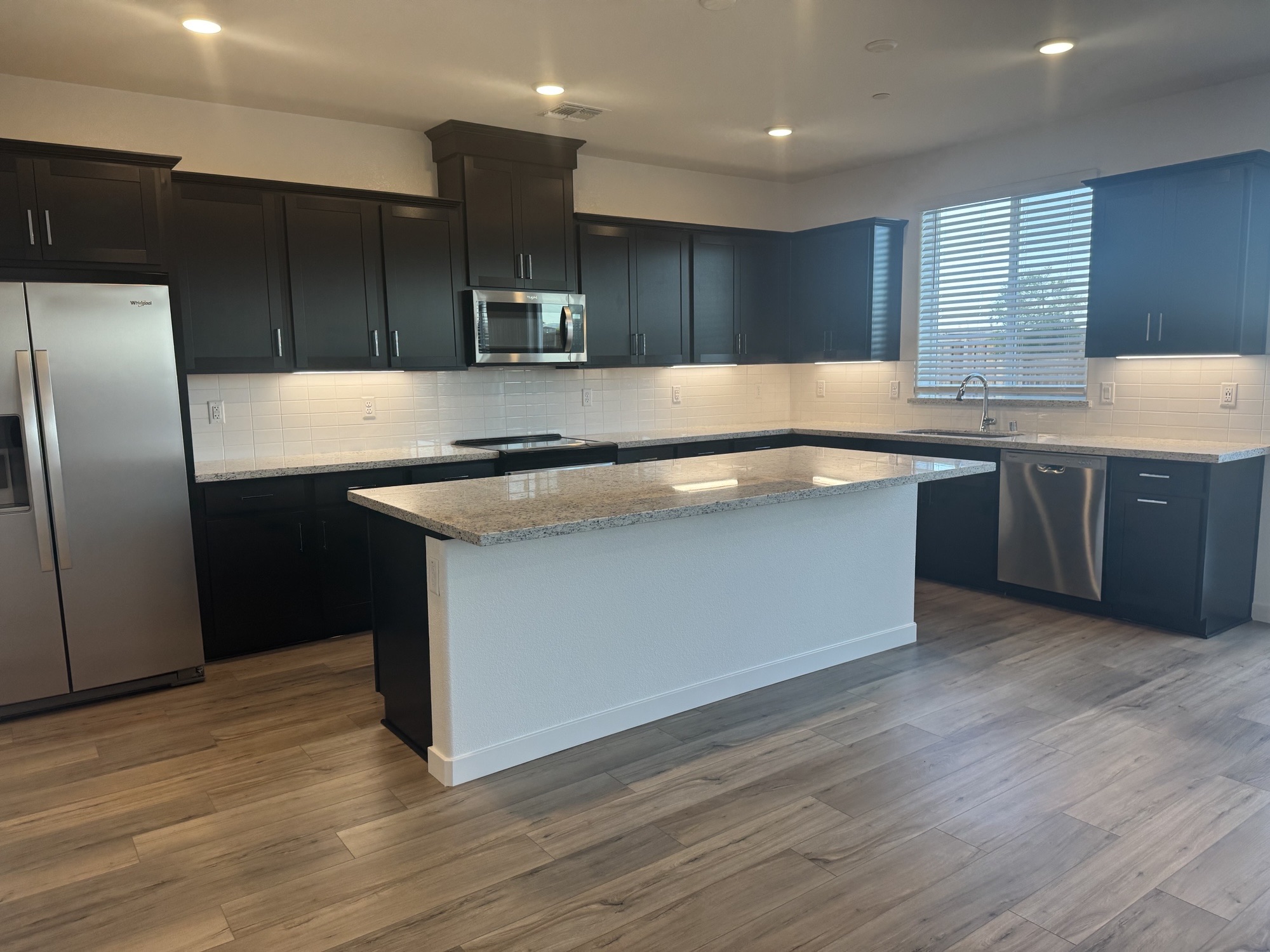 A kitchen with black cabinets.