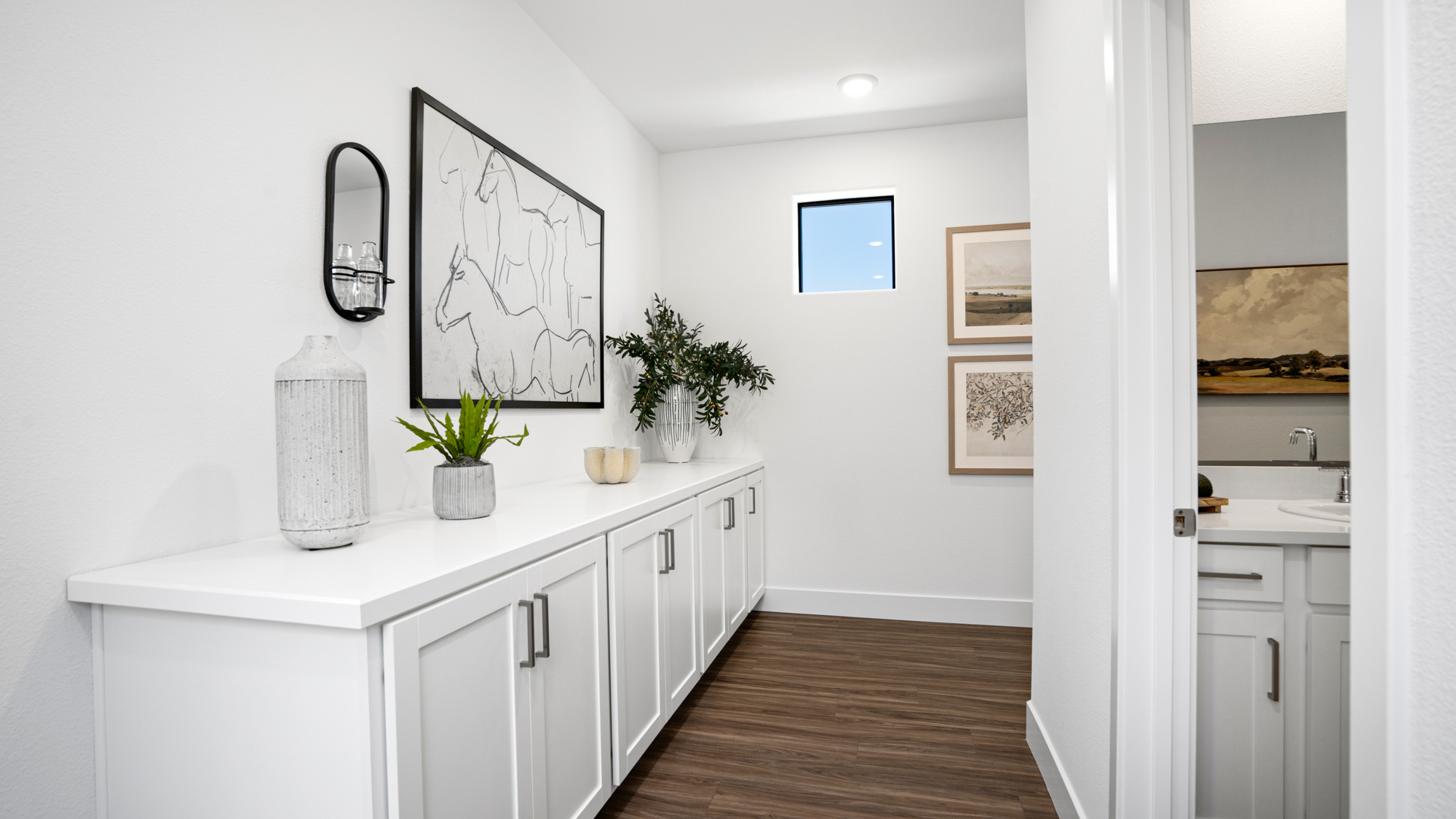 A white kitchen with a wood floor.