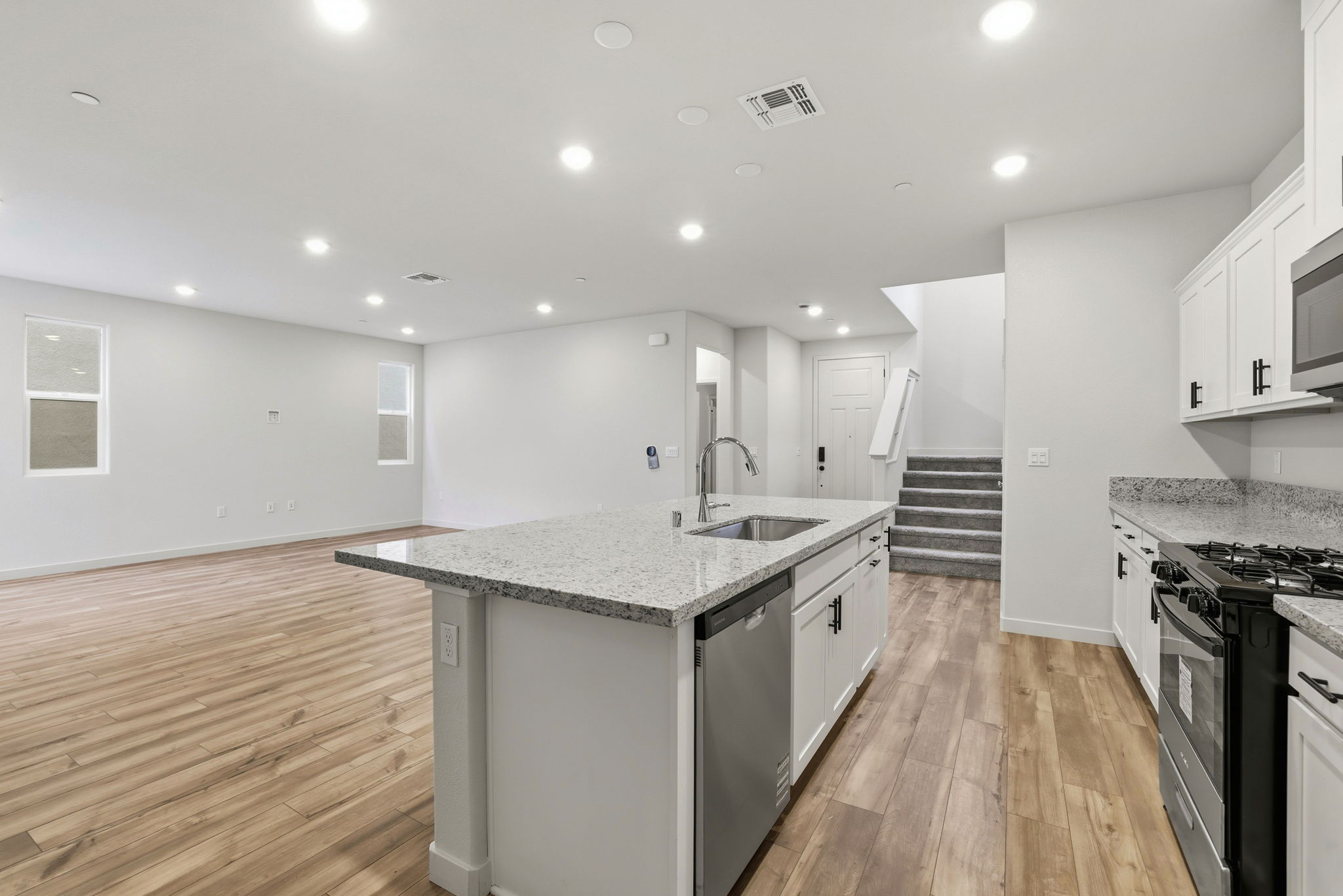A kitchen with white cabinets.