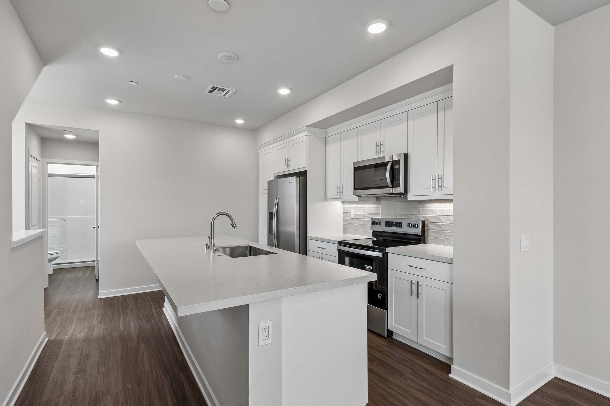 A kitchen with white cabinets.