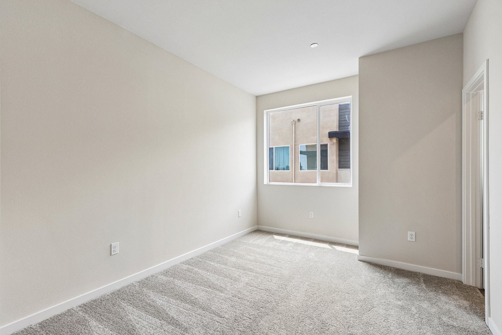 A room with a window and a carpet.