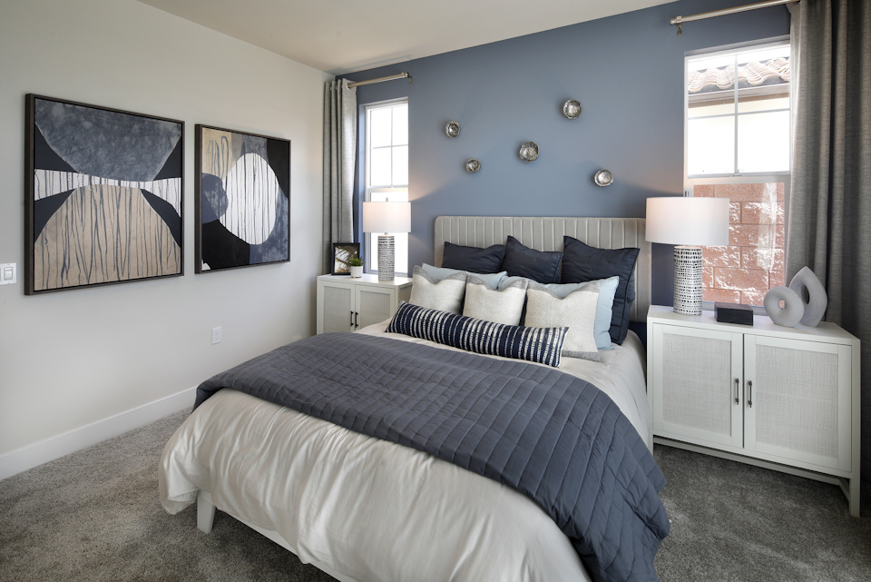 A bedroom with a bed and a lamp.