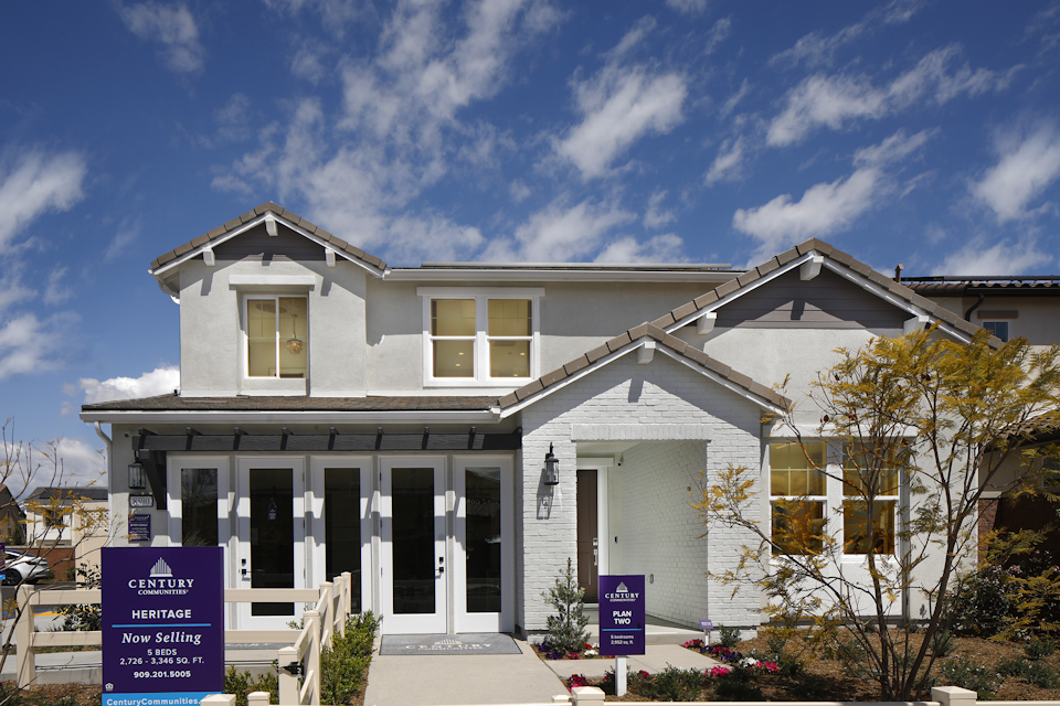A white house with a sign in front of it.