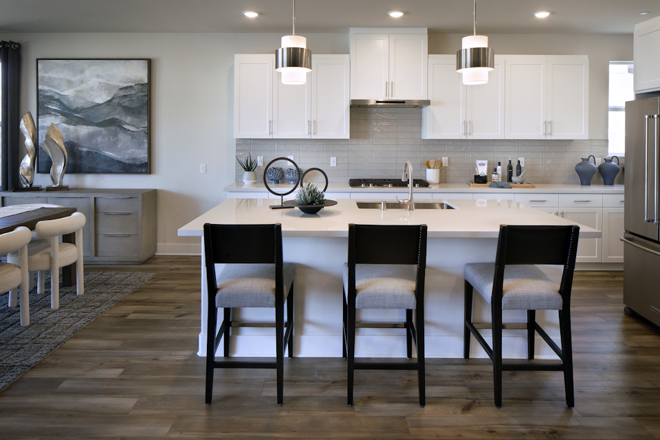 A kitchen with a dining table and chairs.