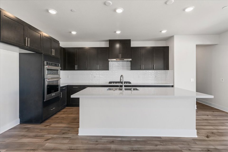 A kitchen with black cabinets.