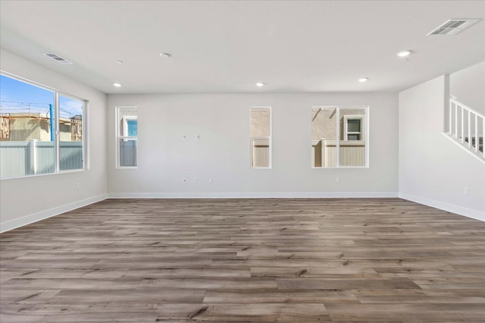 A room with a wood floor and windows.