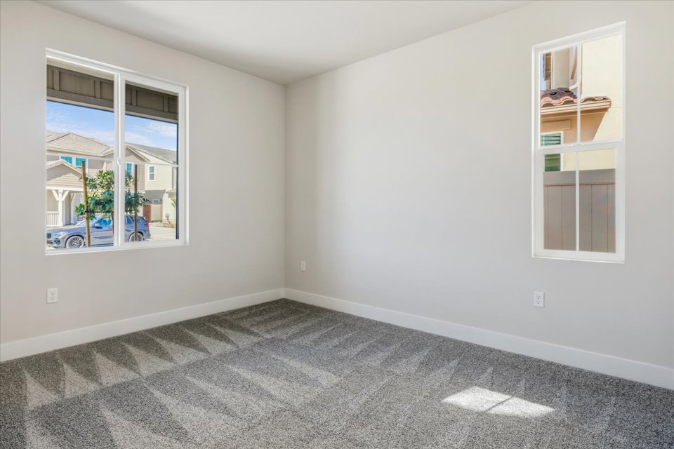 A room with a window and a shelf with books on it.