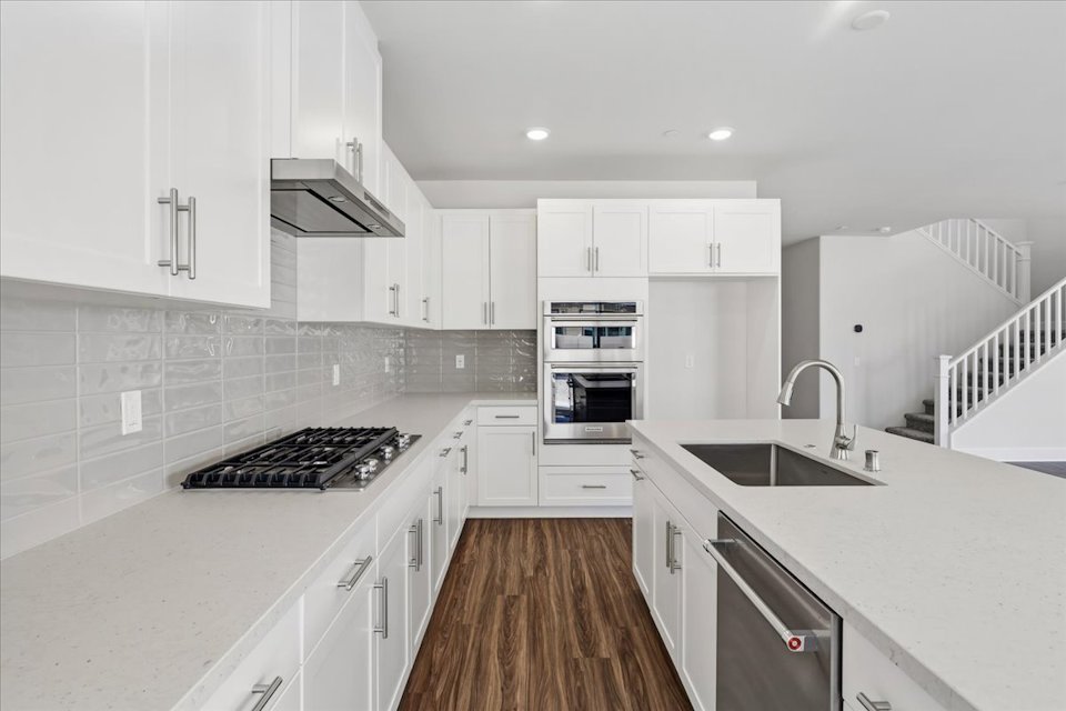 A kitchen with white cabinets.