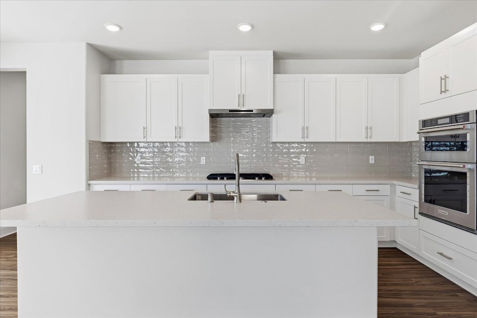 A kitchen with white cabinets.