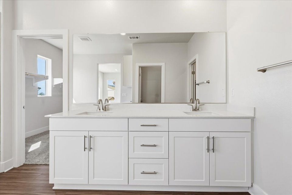 A bathroom with white cabinets.