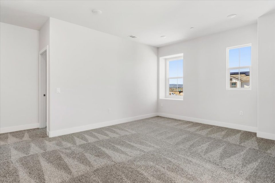 A room with a carpet and windows.