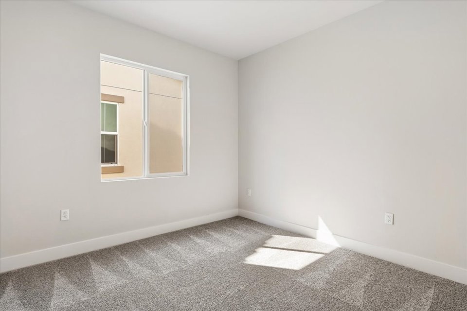 A room with a window and a rug in it.