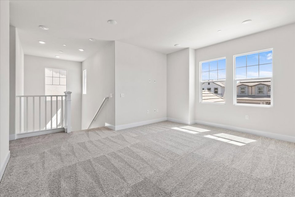 A large empty room with a staircase.