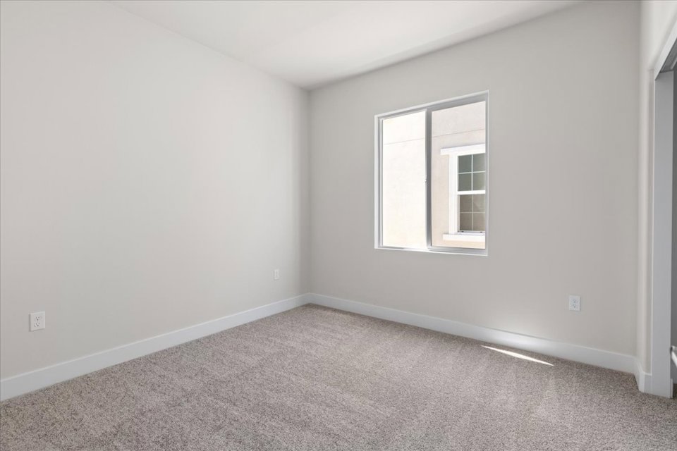 A room with a window and carpet.