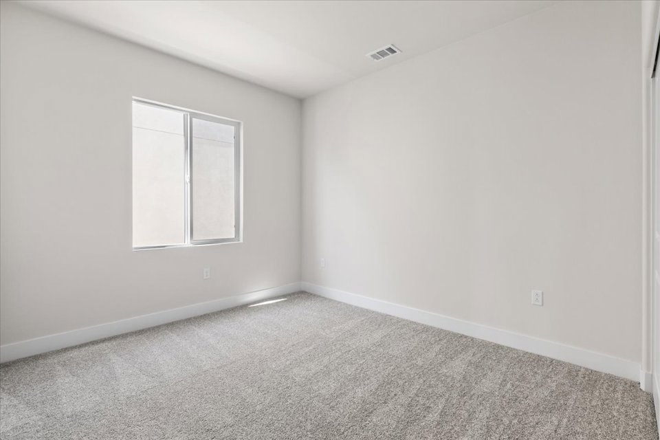 A room with a window and carpet.