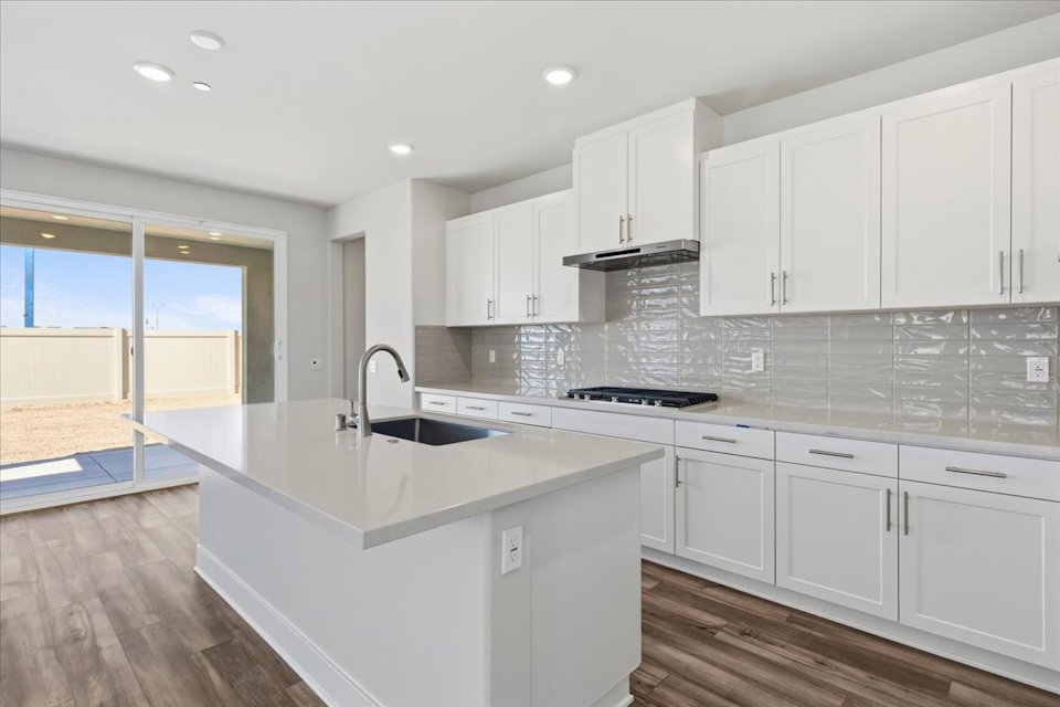 A kitchen with white cabinets.