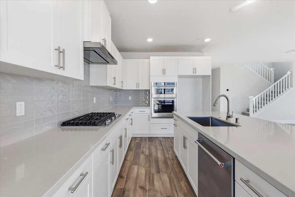 A kitchen with white cabinets.
