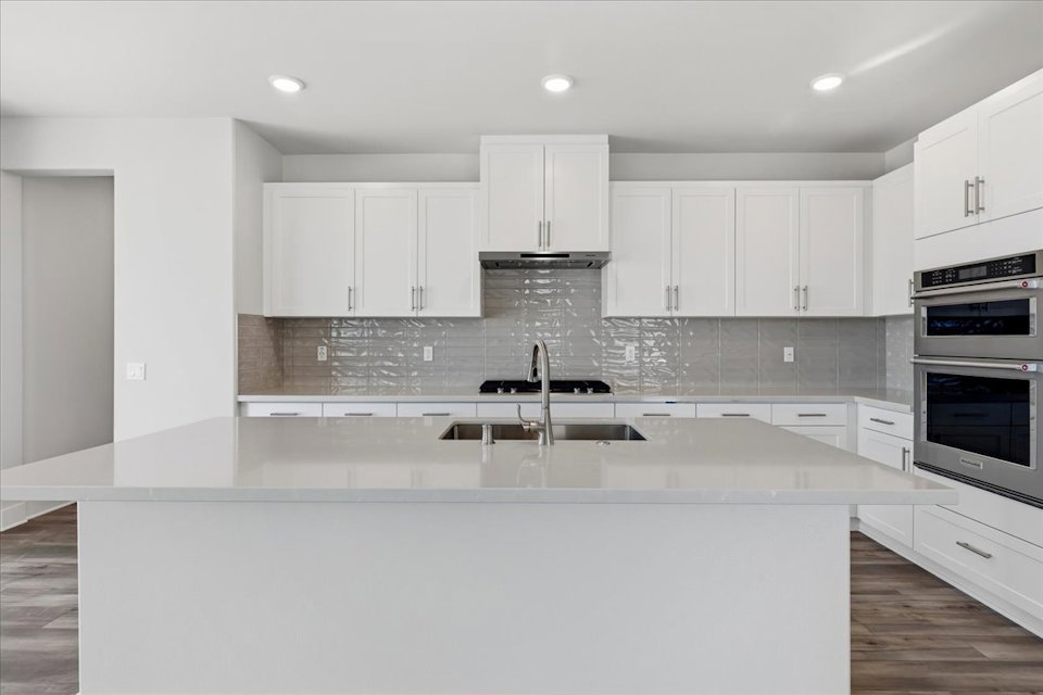 A kitchen with white cabinets.