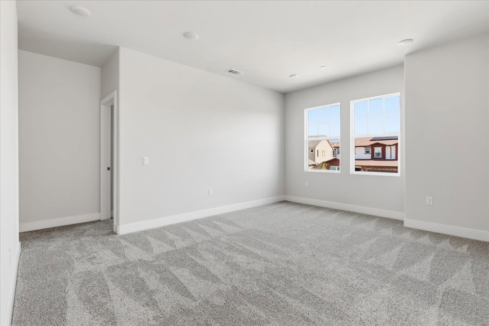 A room with a carpet and a window.