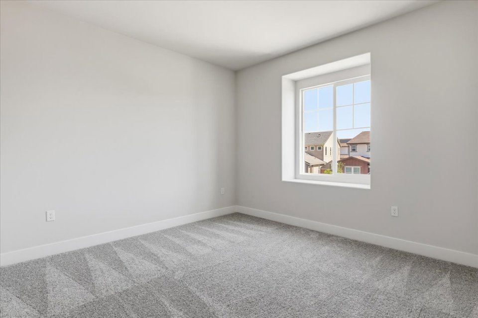 A room with a window and a carpet.