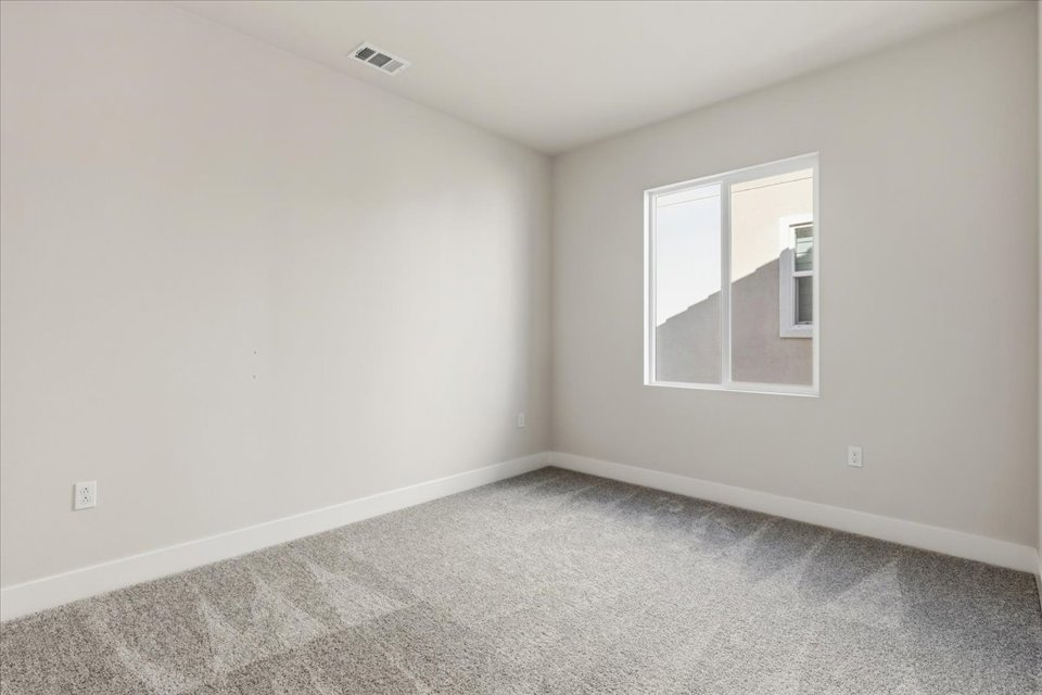 A room with a window and carpet.