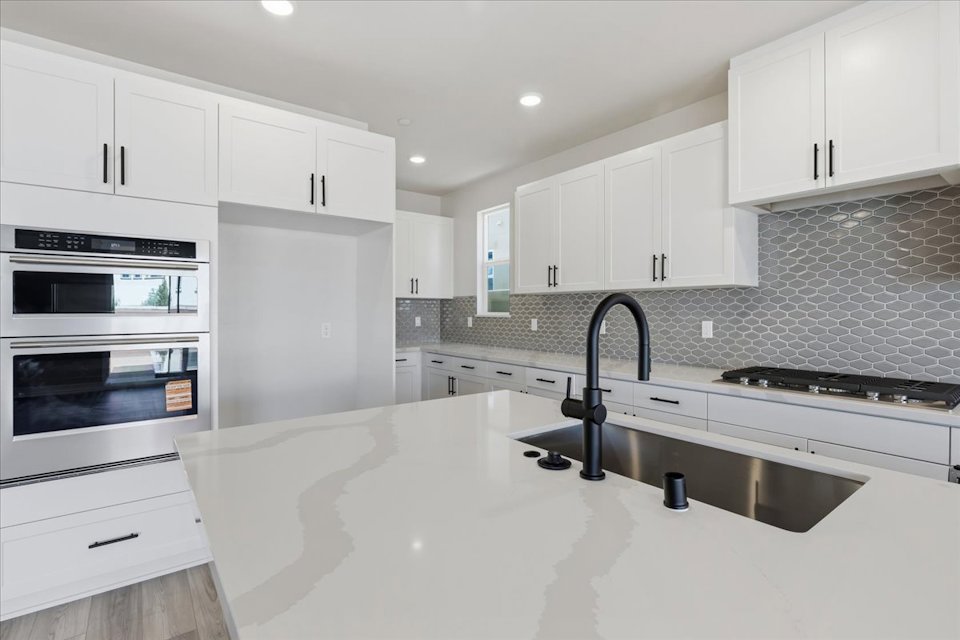 A kitchen with white cabinets.