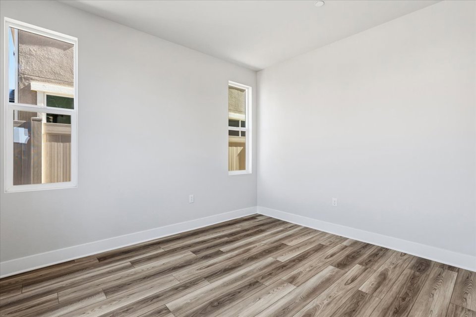 A room with a wood floor and windows.