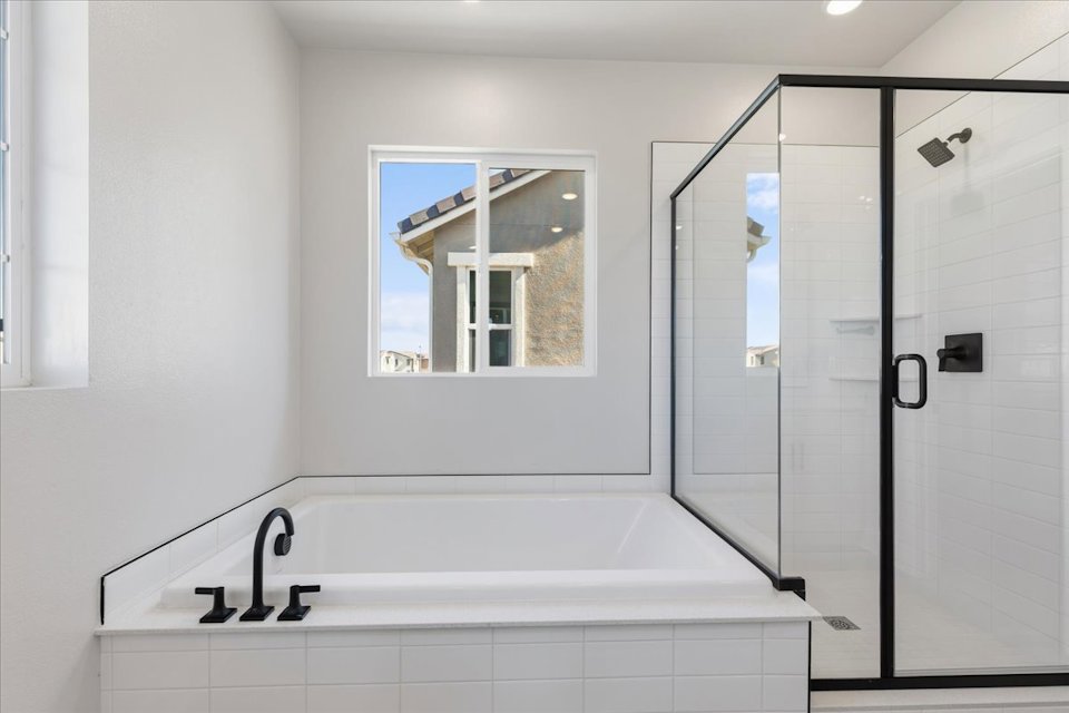 A bathroom with a bathtub and shower.