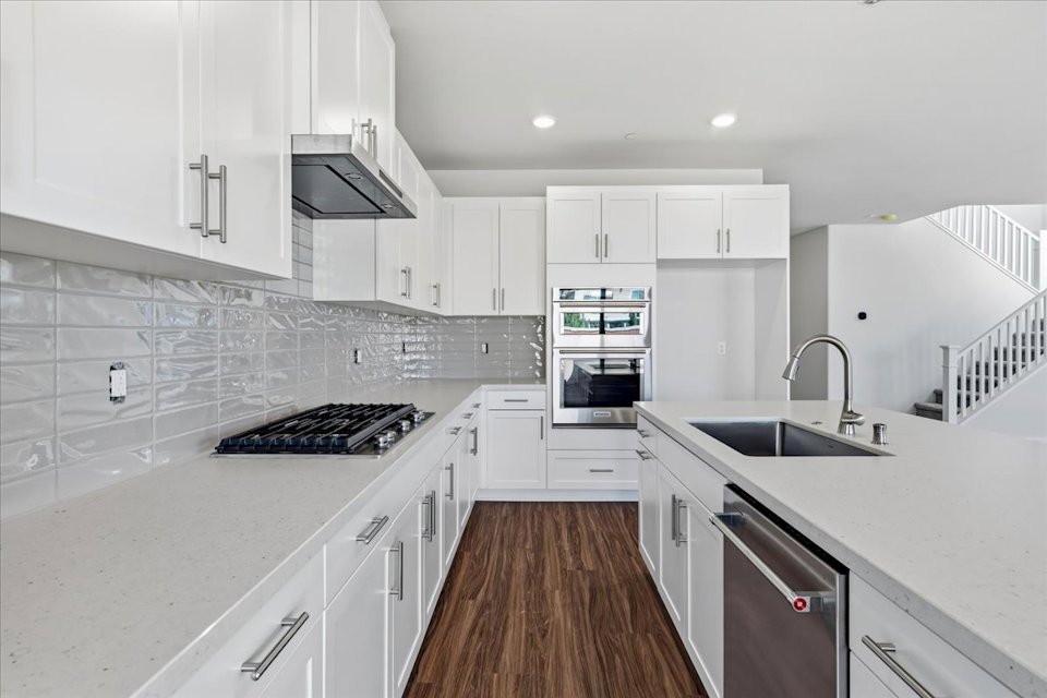 A kitchen with white cabinets.