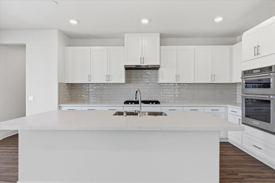 A kitchen with white cabinets.