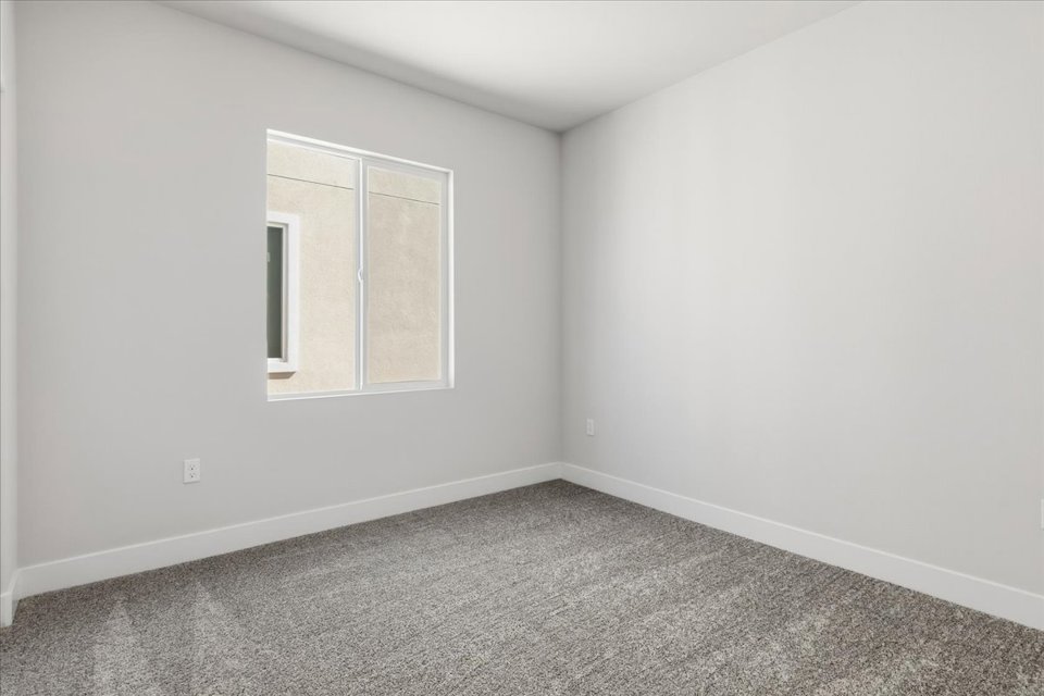 A room with a window and a carpet.