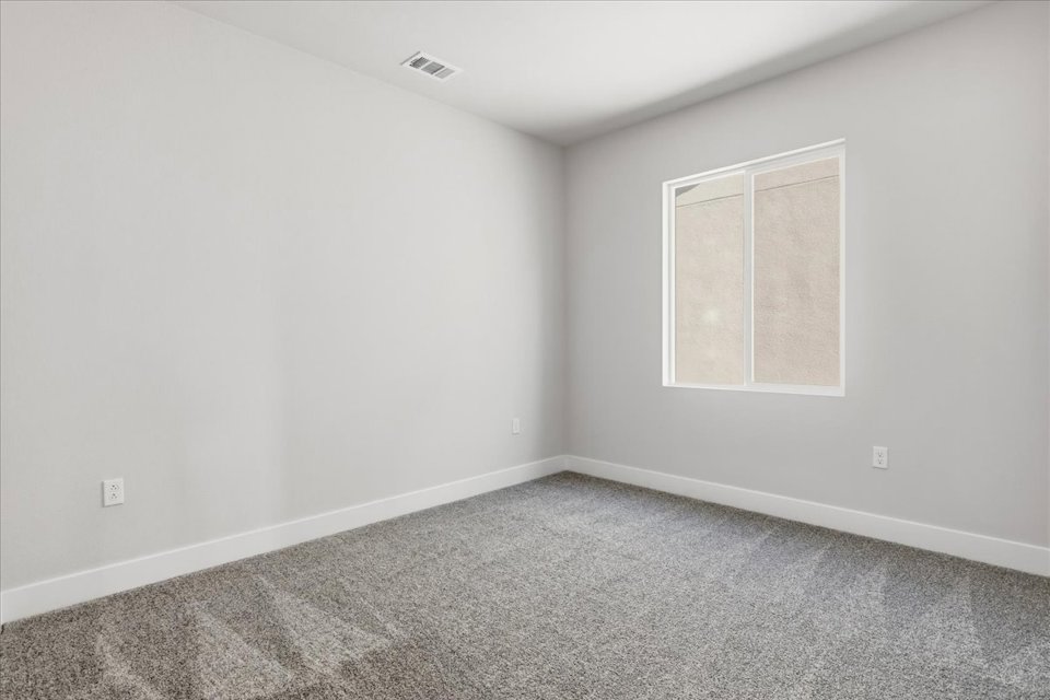 A room with a window and carpet.