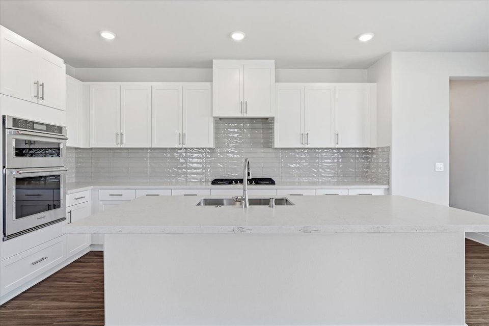 A kitchen with white cabinets.
