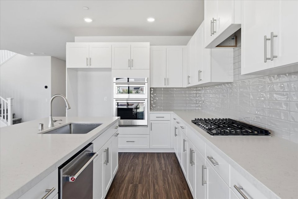 A kitchen with white cabinets.