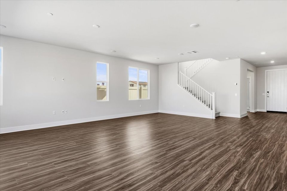 A large empty room with a staircase.