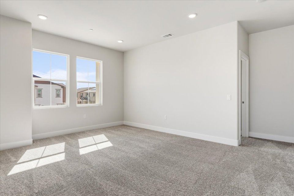 A room with a carpet and windows.