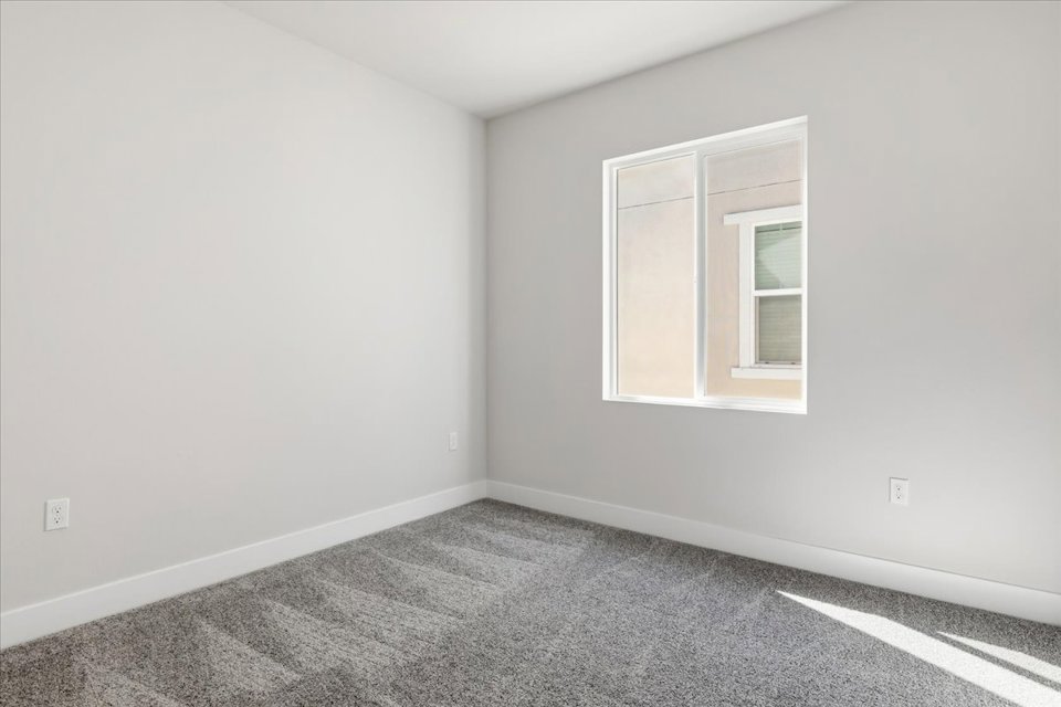 A room with a window and a carpet.