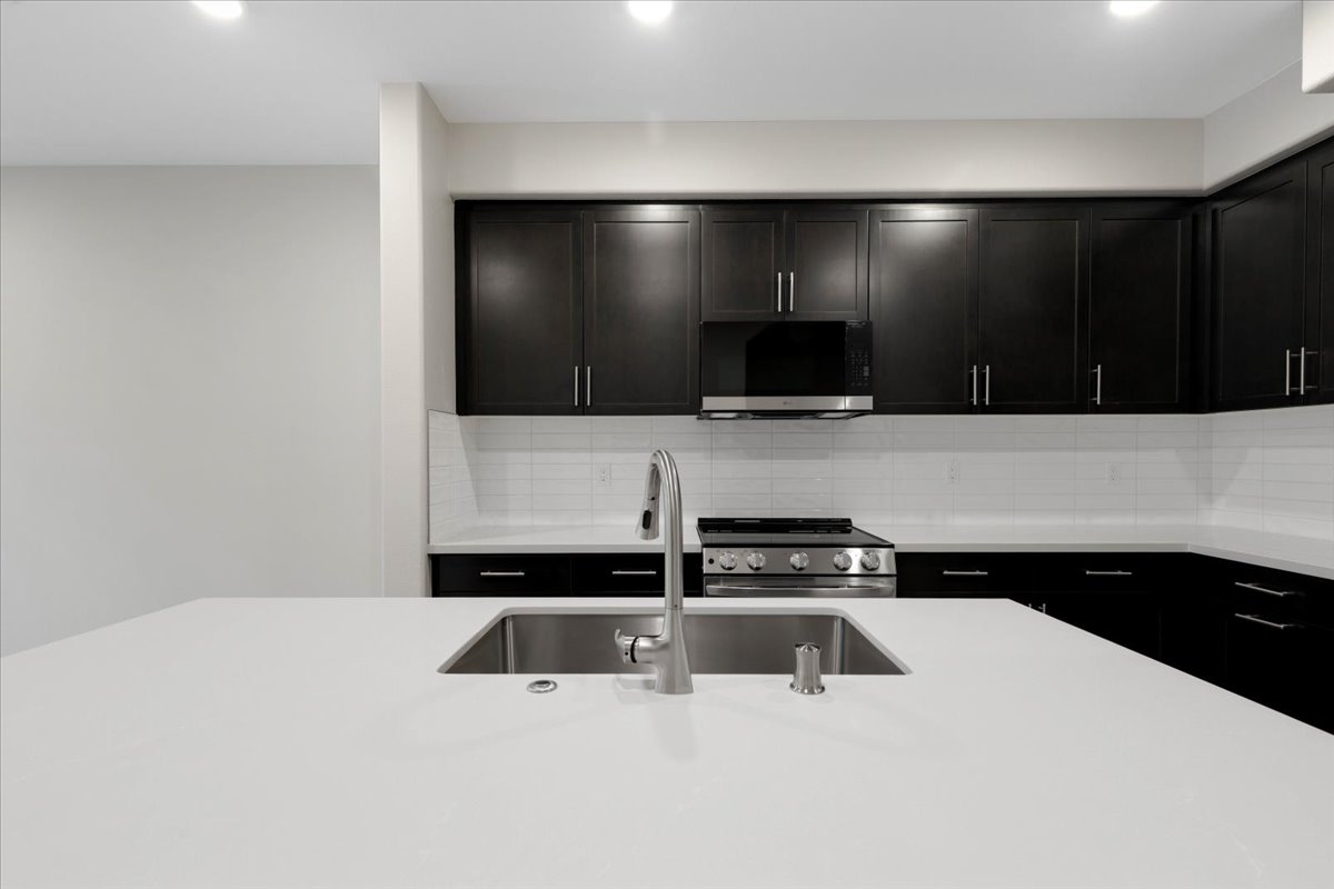 A kitchen with black cabinets.