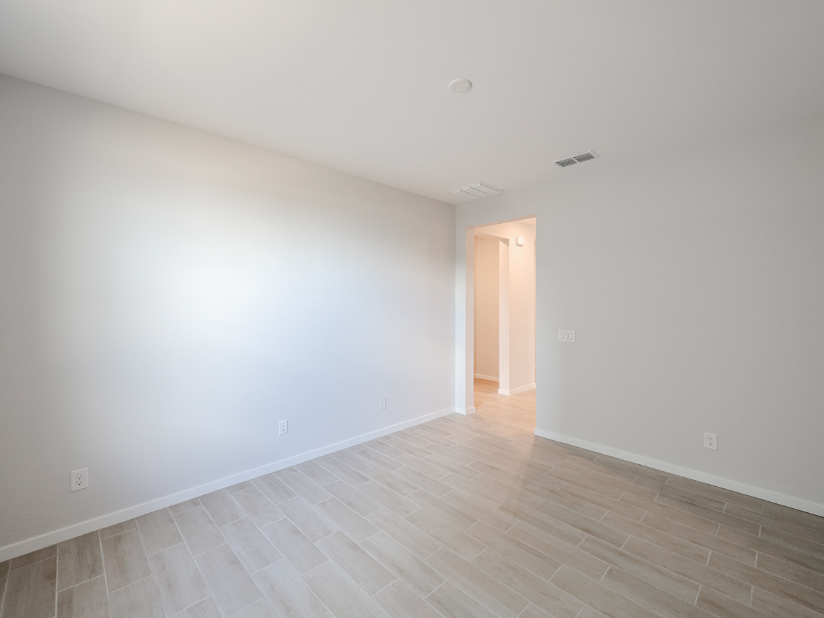 A room with a wood floor and a white wall.