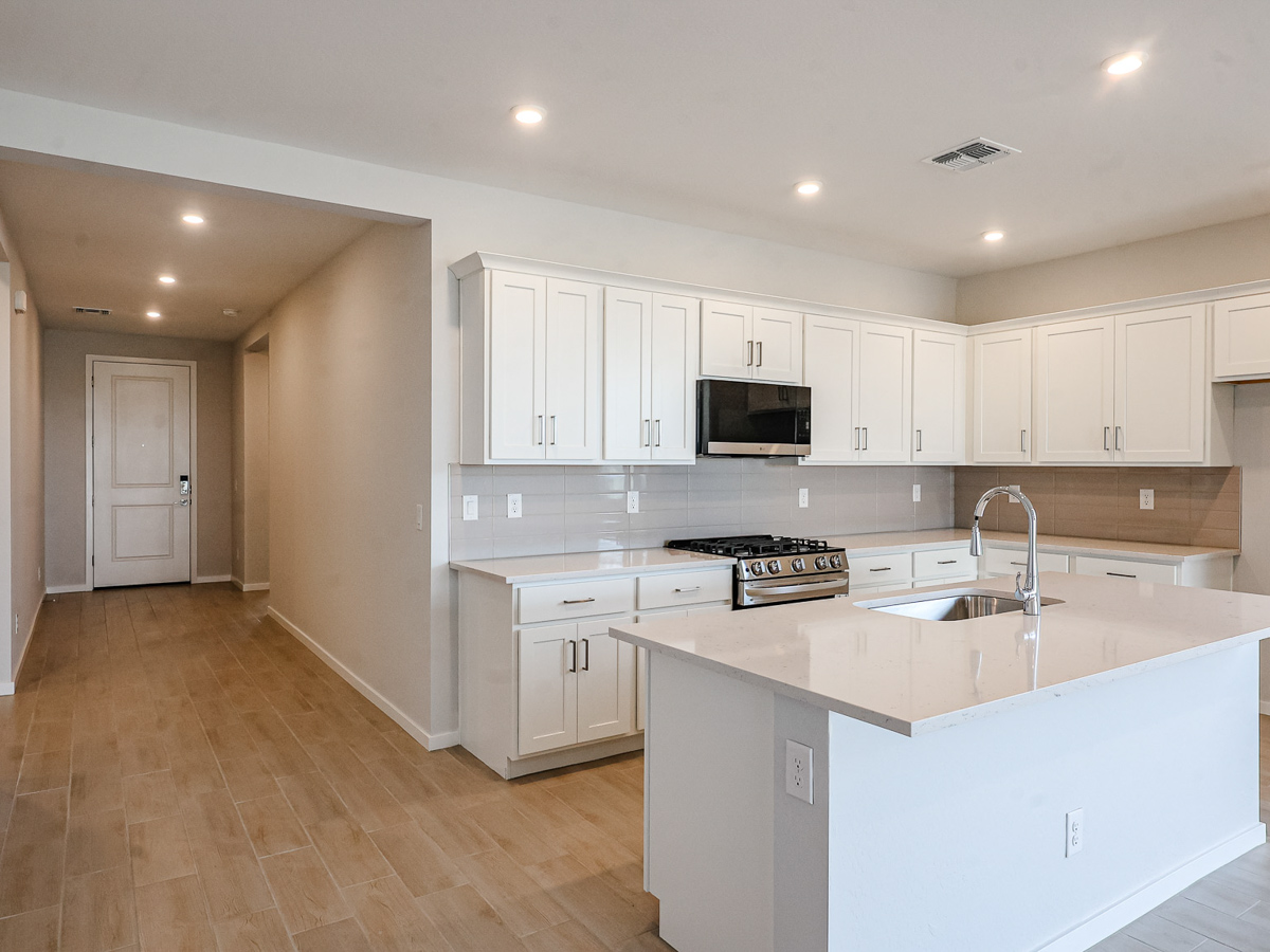 A kitchen with white cabinets.