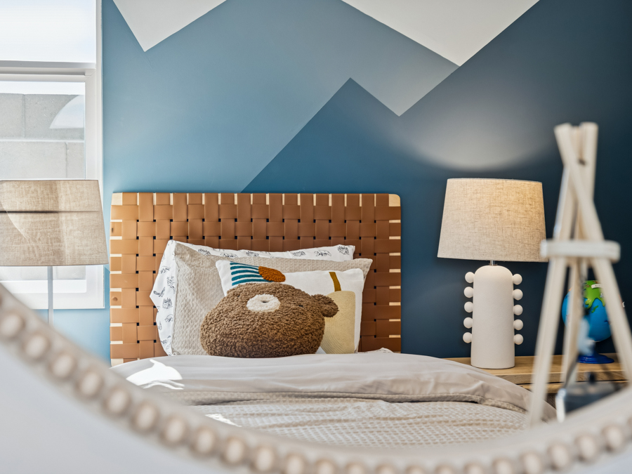 A bed with a lamp and a pillow.