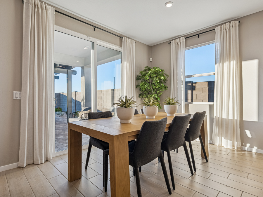 A dining room table with chairs and a large window.