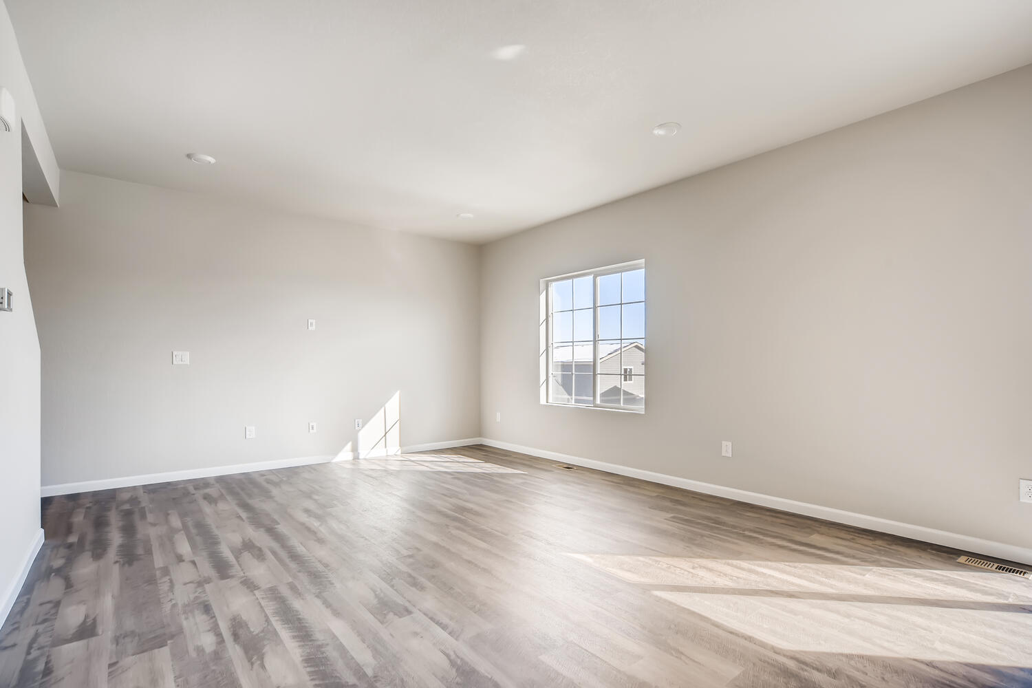 A room with a wood floor and a window.
