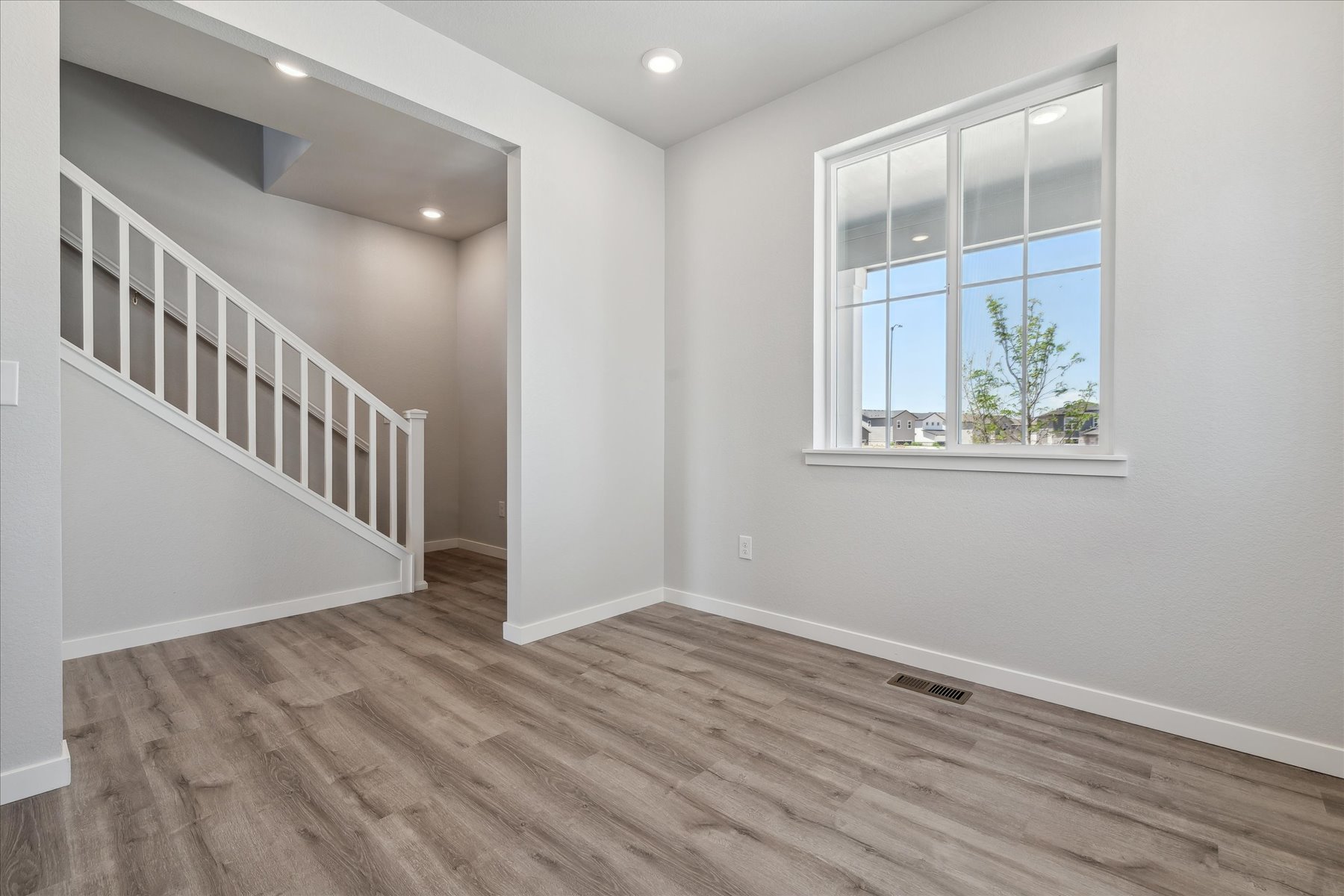 A room with a wood floor and a window with a wood floor.