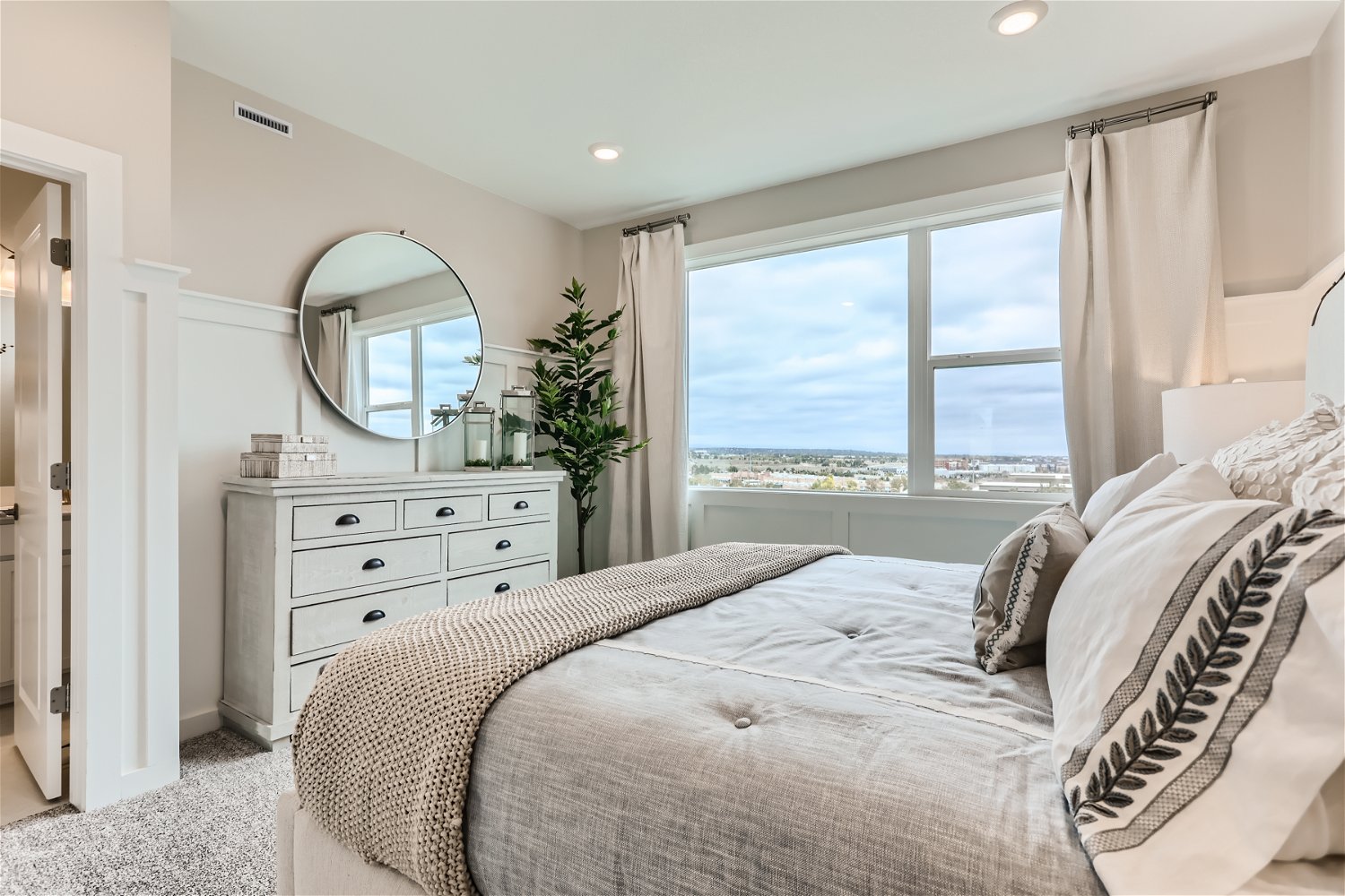 A bedroom with a large window.