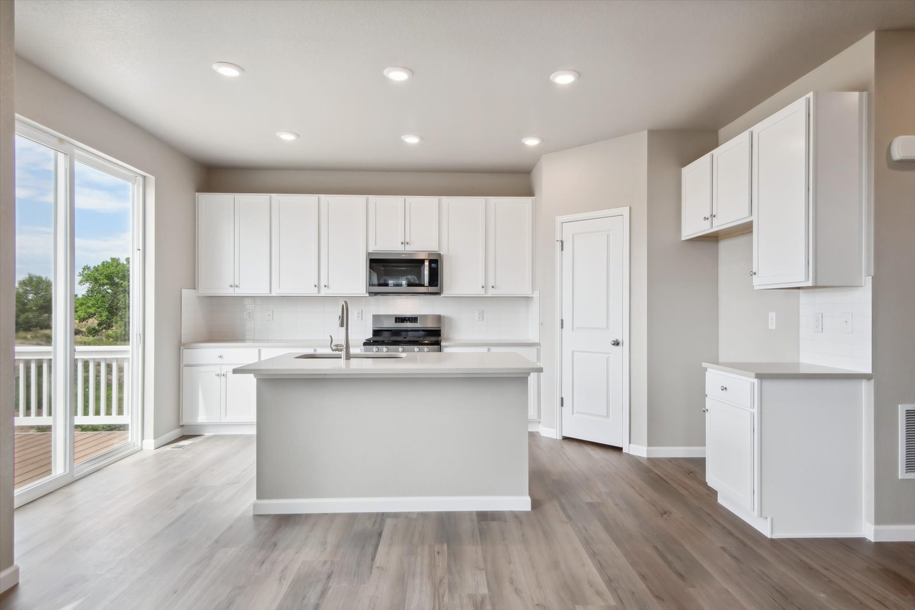 A kitchen with white cabinets.