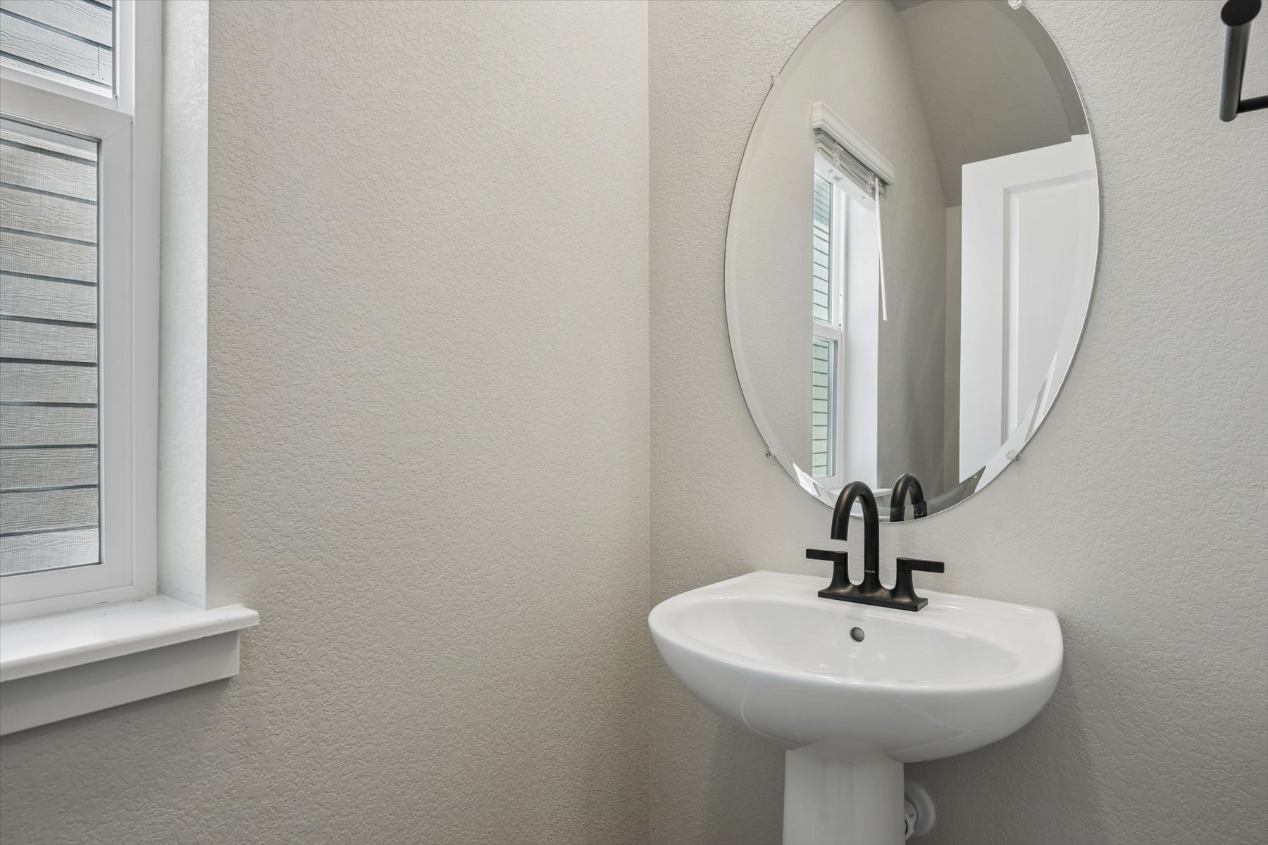A bathroom with a round mirror.